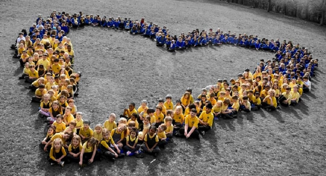Pupils from Hotspur Primary School show their support for Ukraine, by wearing yellow and blue, and forming a heart shape, as part of their work towards becoming a School of Sanctuary