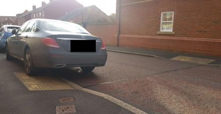 Photograph of vehicle parked partly over dropped kerb