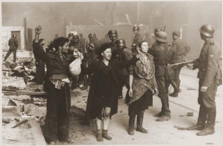 Two women and a man surrender to armed German troops following the Warsaw Ghetto uprising