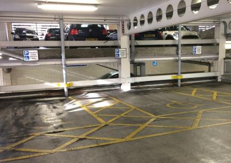 Disabled bays within a car park, bays are marked in yellow with the disabled symbol in the middle of the parking bay and a sign at the front of the bay