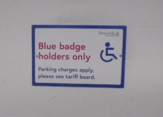 Disabled sign that can be found in each disabled parking bay. The sign has a picture of the disabled wheelchair symbol and states ‘Disabled badge holders only  Parking Charges apply please see tariff board’
