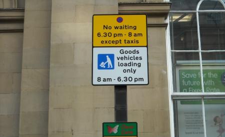 Dual use sign the first part of the sign is yellow with a no waiting symbol and states ‘No waiting 6.30pm – 8am except taxis’. Underneath is the standard goods vehicle loading sign which has a picture of the loading/unloading symbol and states ‘Goods vehicle loading only 8am – 6.30pm’