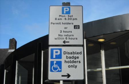 Different restrictions within a permit street. First sign advises ‘Mon – Sat 8am – 6.30pm Permit holders only or 2 hours No return within 6 hours’ arrow point left. Second sign advises ‘Disabled badge holders only’, arrow pointing right