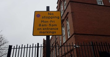 Sign adjacent to school keep clear marking, states, ‘No stopping Mon – Fri 8am – 5pm on entrance markings’