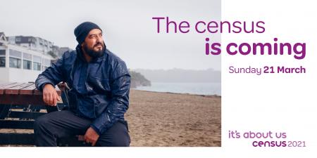 Photo of a man sitting near a beach with a message that says the census is coming. 