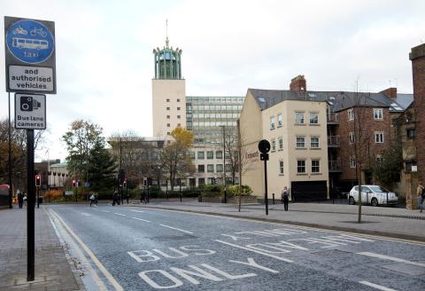Picture shows a road with a bus lane on it and Newcastle Civic Centre in the background.