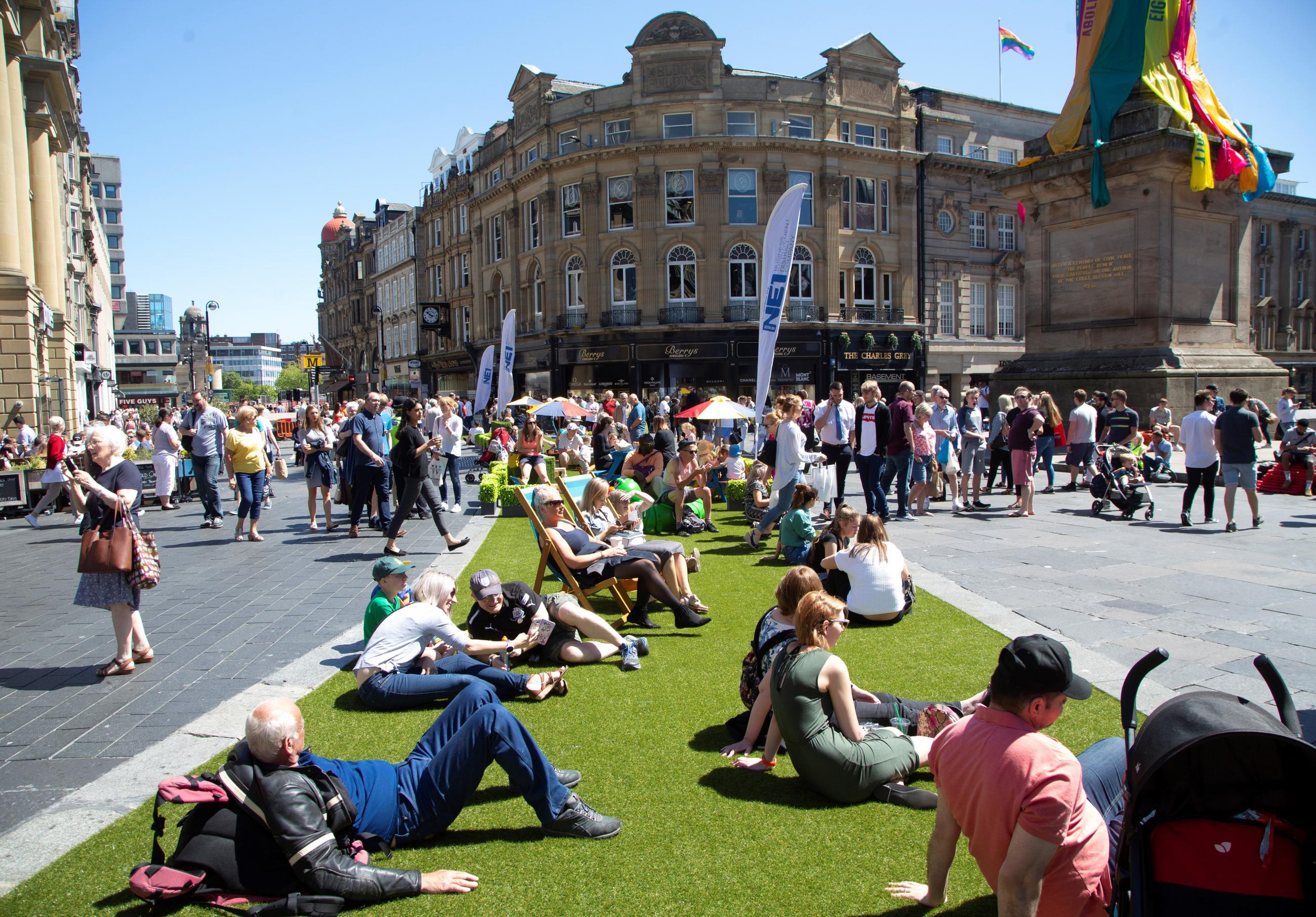 Photo showing people on Blackett Street with artificial grass where the road normally is.
