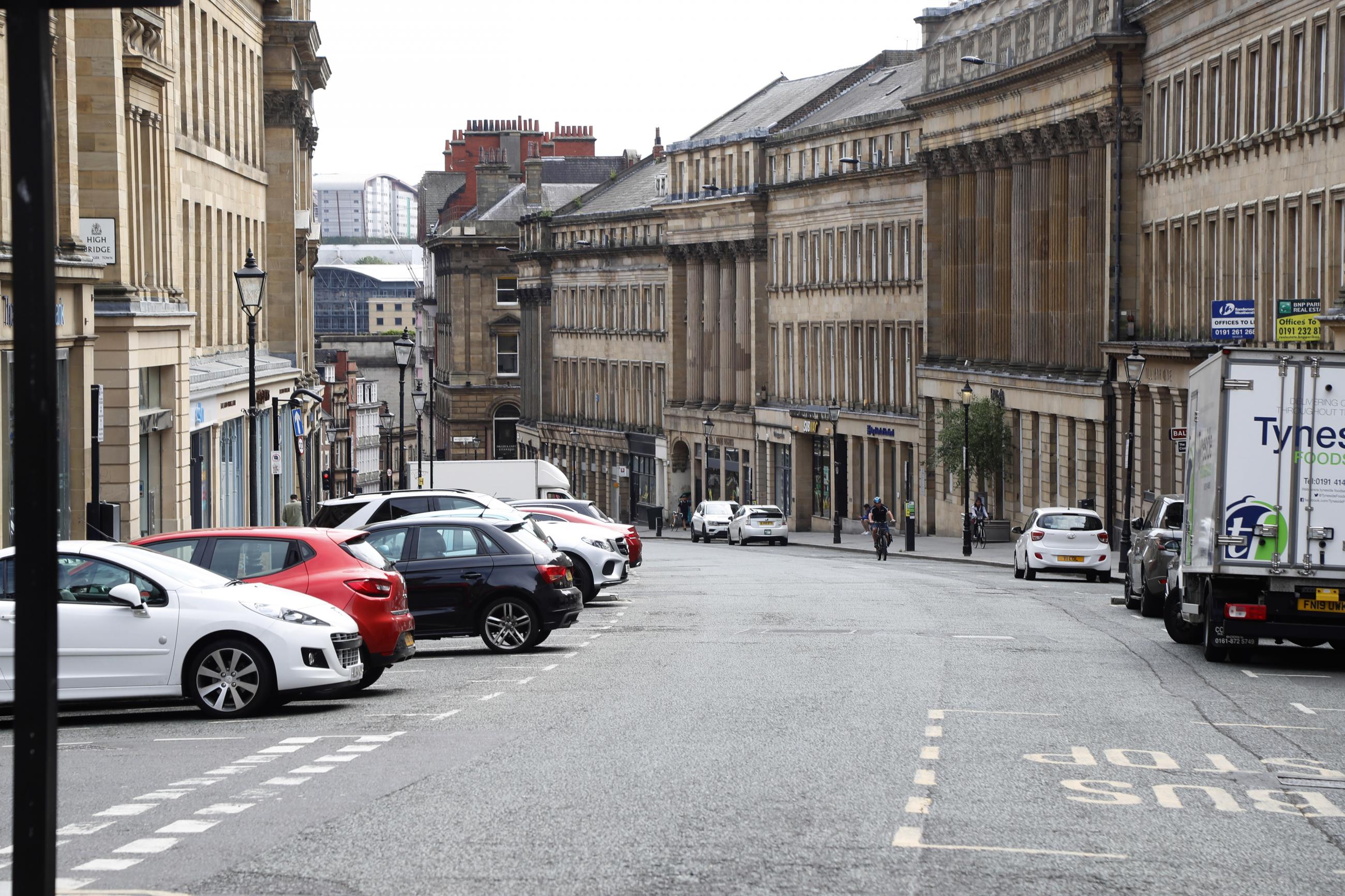 Photo shows the view down Grey Street in Newcastle with cars and a van parked on either side.