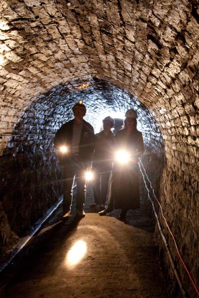 3 people in crash helmets in a Victorian Tunnel